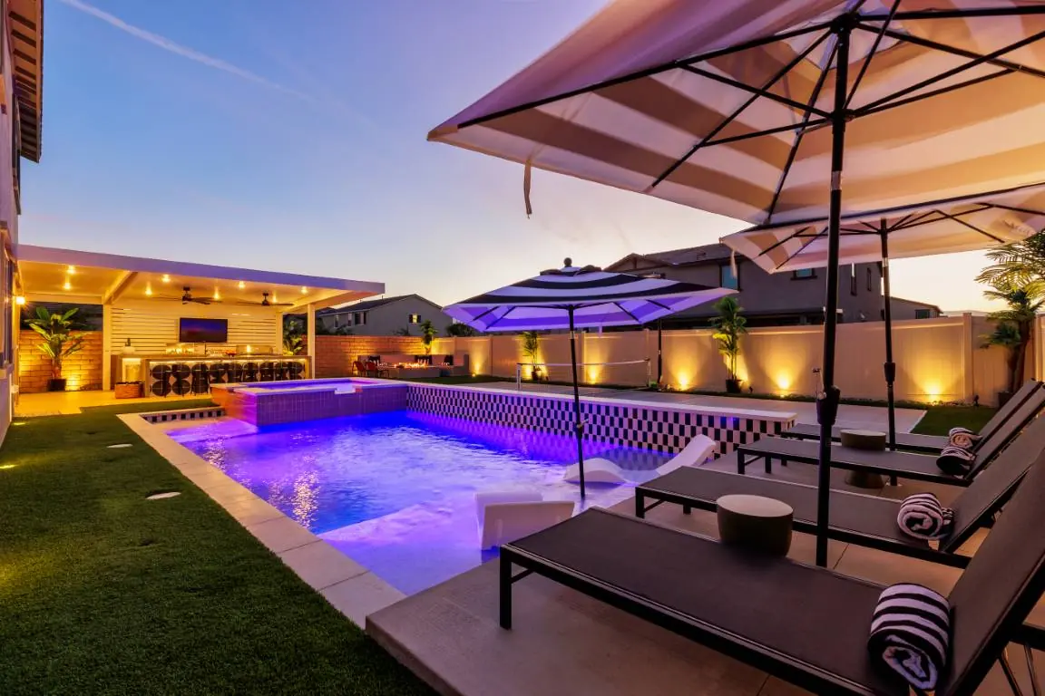 Cabana, umbrella and color-lit pool at night