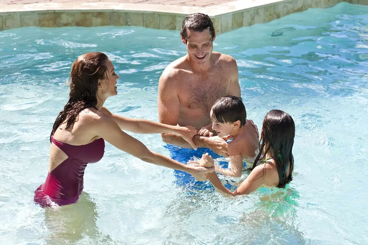 A family laughing together in a swimming pool