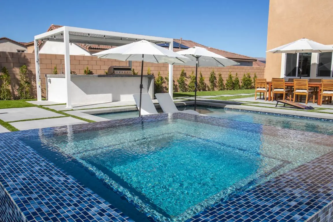 Pool with mosaic tile and white shade structures