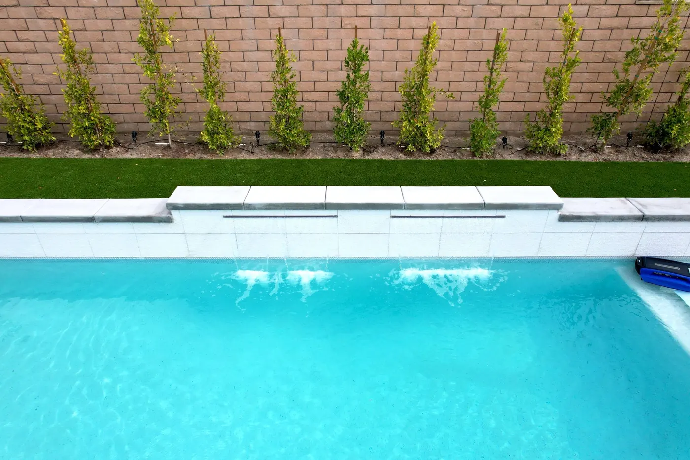 Piscina turquesa brillante con una cascada de lámina de agua