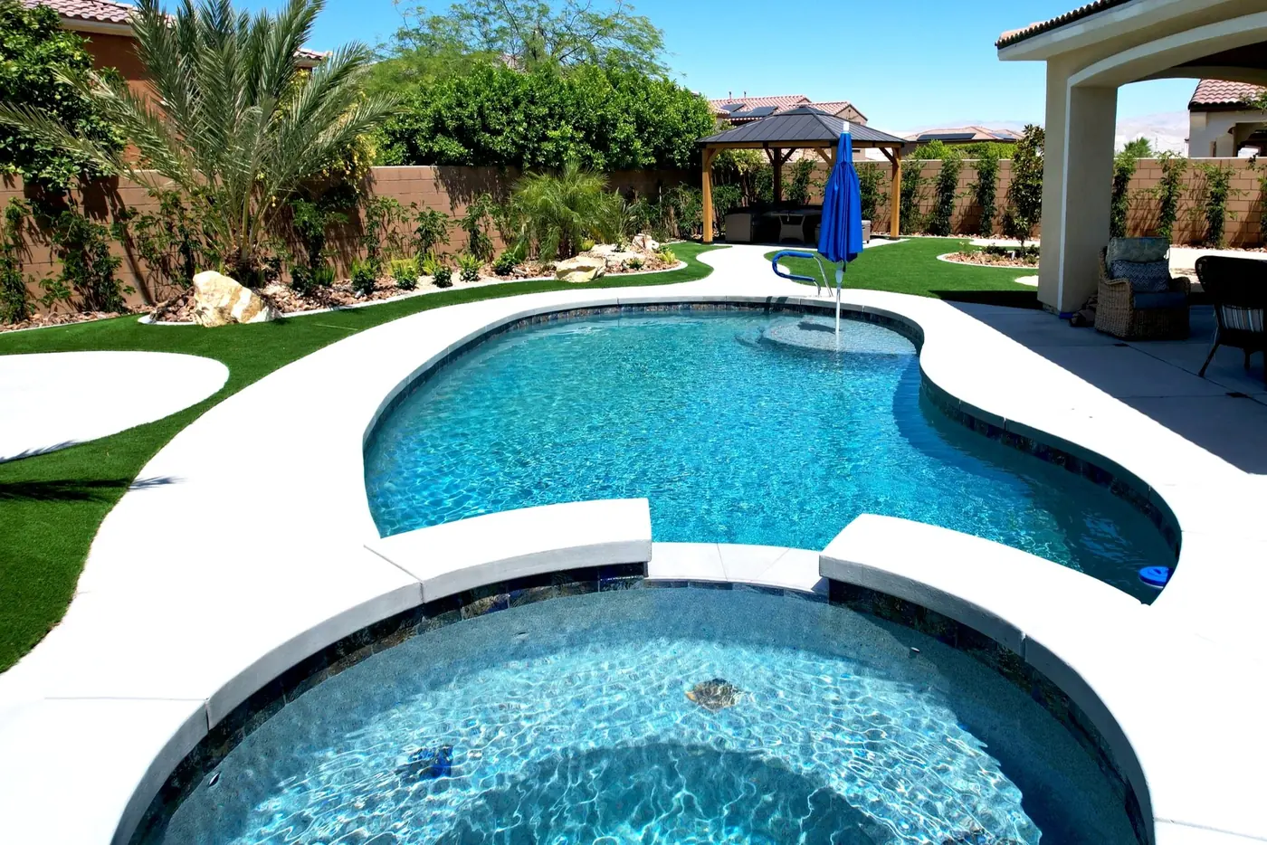 Freeform pool and spa with a shaded patio